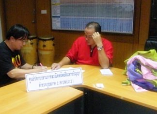 An officer takes down details from suspect Korn Thanormsupthawee.